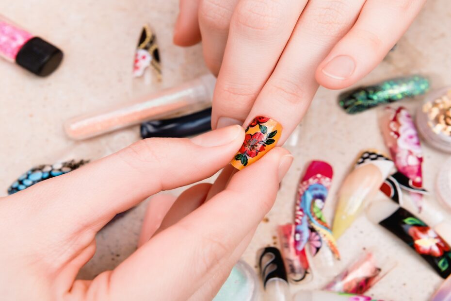 girl-trying-artificial-nails-tips-with-flower-nail-design-930x620