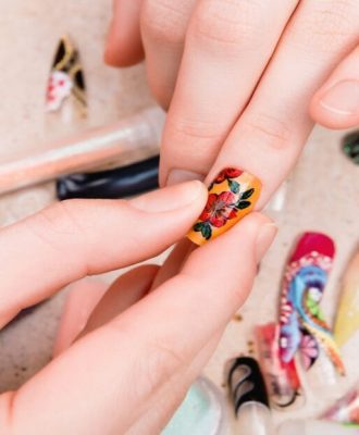 girl-trying-artificial-nails-tips-with-flower-nail-design-930x620